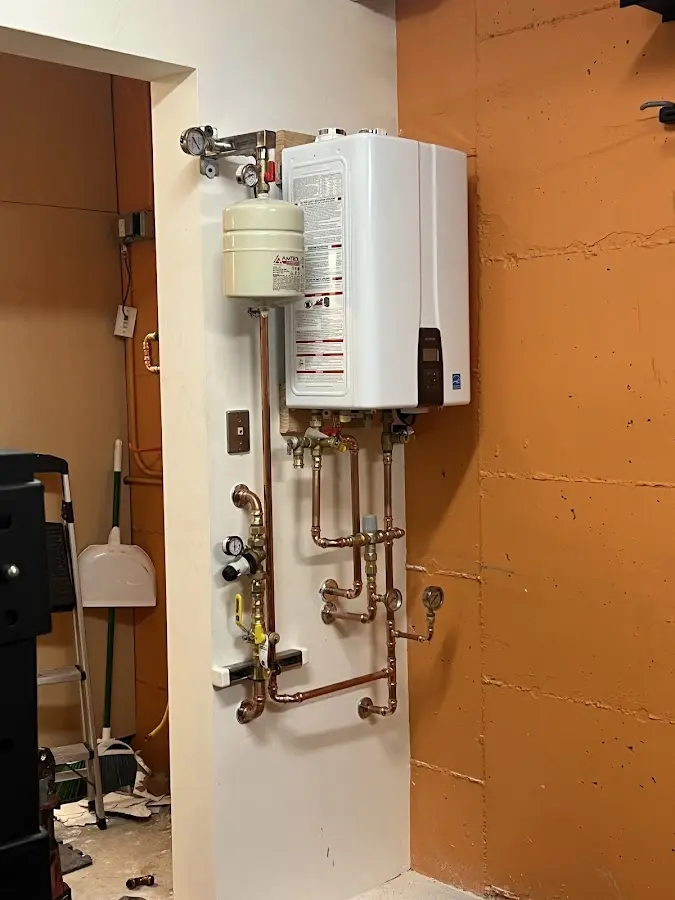 Plumbing technician inspecting water heater connections in Gustine